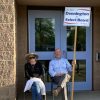 Select Board members Marguerite Landry and Sam Stivers found a place out of the sun to demonstrate their support for Andrew Dennington yesterday (photo by Beth Melo)