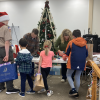 Kids get their just-purchased gifts wrapped at the 2025 annual Kids Shop (photo by Beth Melo)