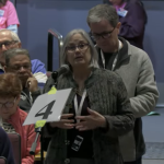 Meme Lutrell explains to Town Meeting the Planning Board's support for the proposed ADU zoning bylaw change (image cropped from video)